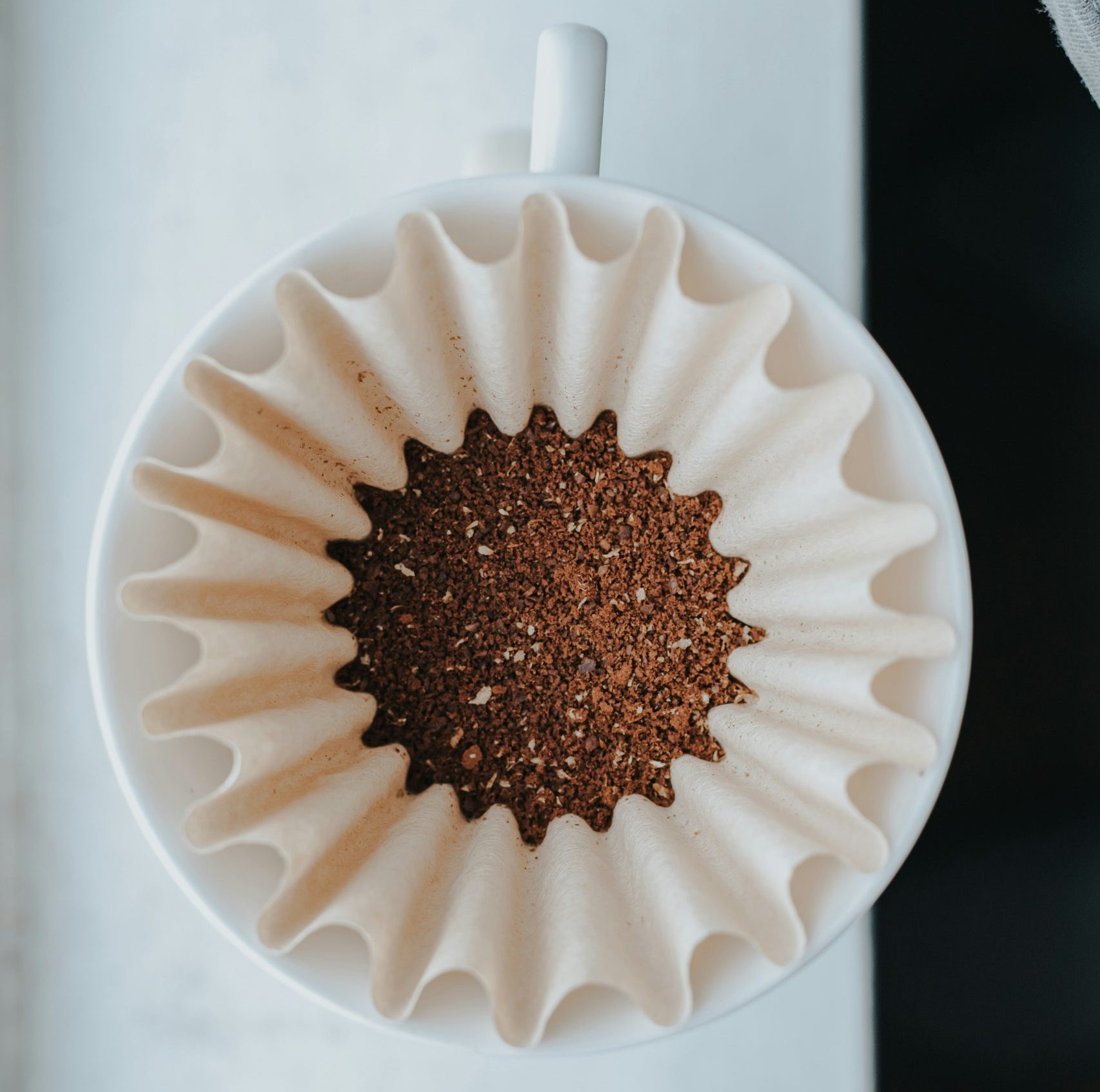 Three elegant V60 pour-over coffee setups with freshly brewed coffee in glass carafes, showcasing the artistry and precision of advanced brewing techniques.